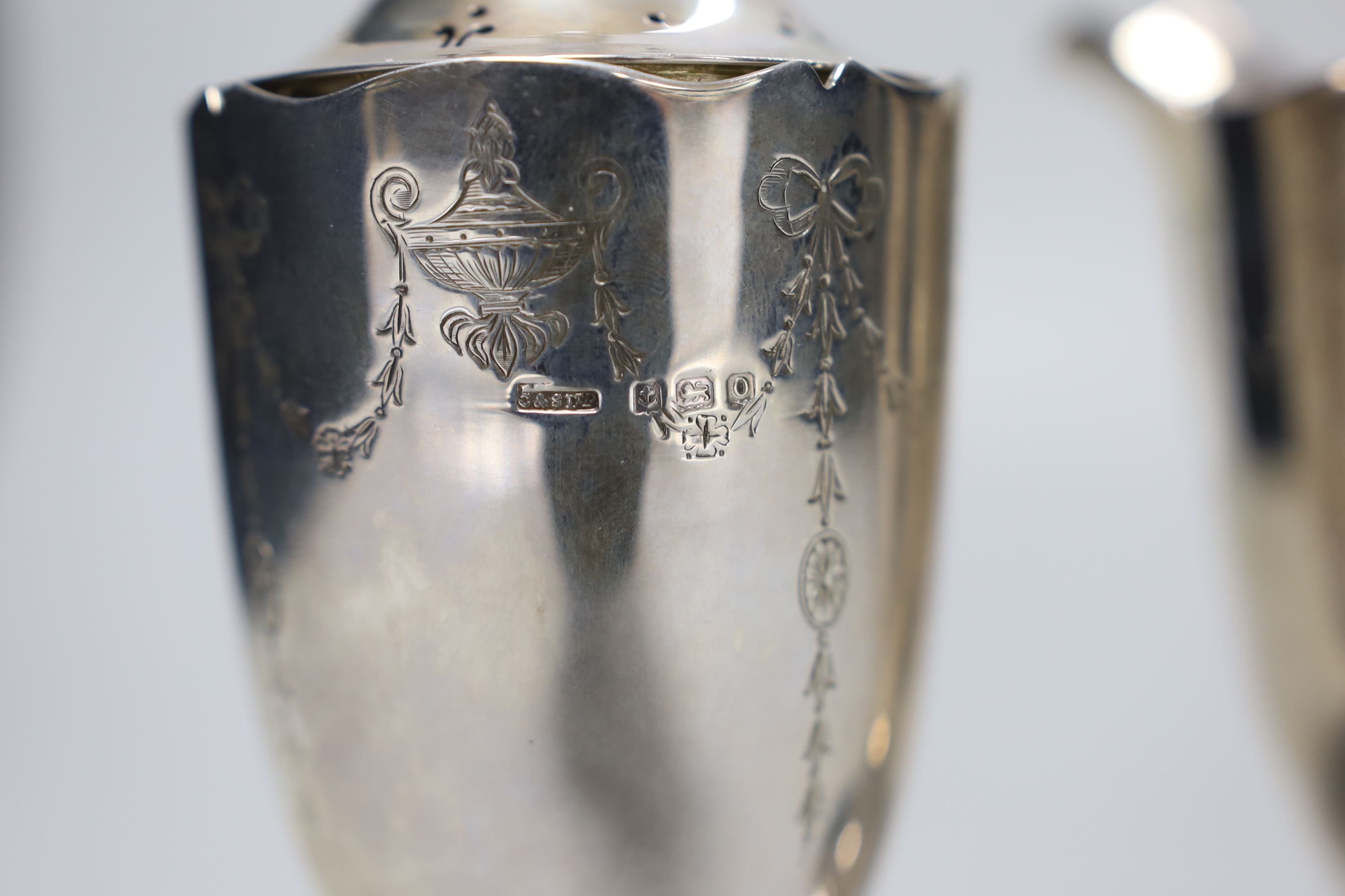 A George V chased silver cream jug and matching sugar caster, Collingwood & Sons Ltd, Birmingham, 1913, caster 15.7cm, 12.2 oz.